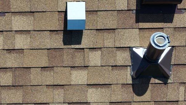 Close view of new pipe and vent flashings set into a shingle field