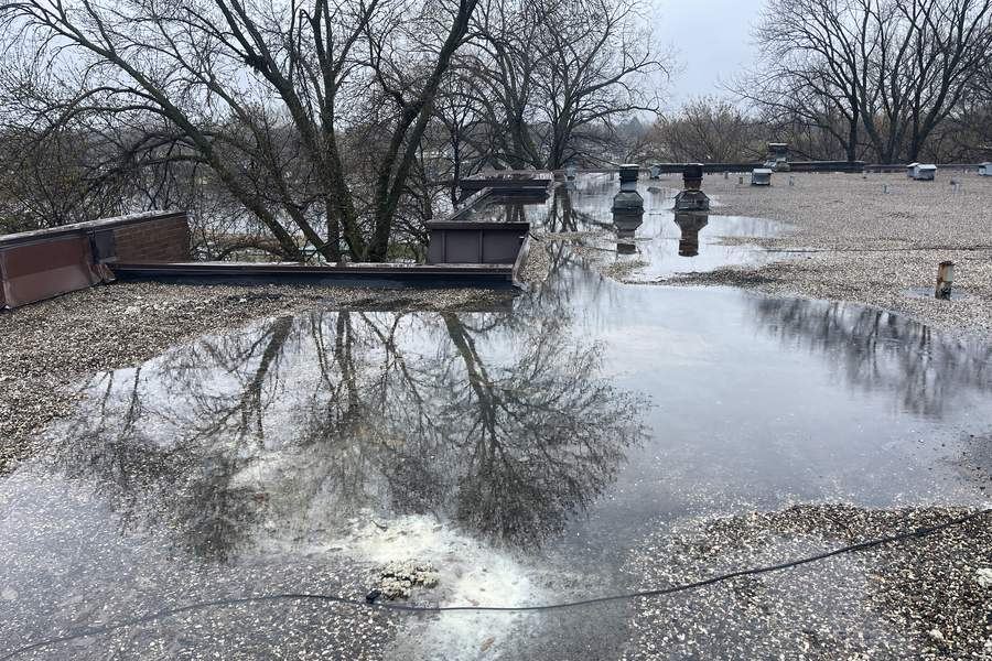 Standing water ponding on a low slope roof after rain