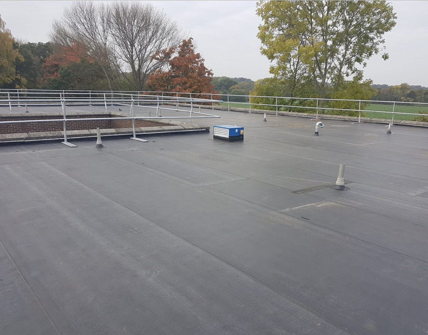 Single ply EPDM membrane roof with seams and edge detail visible