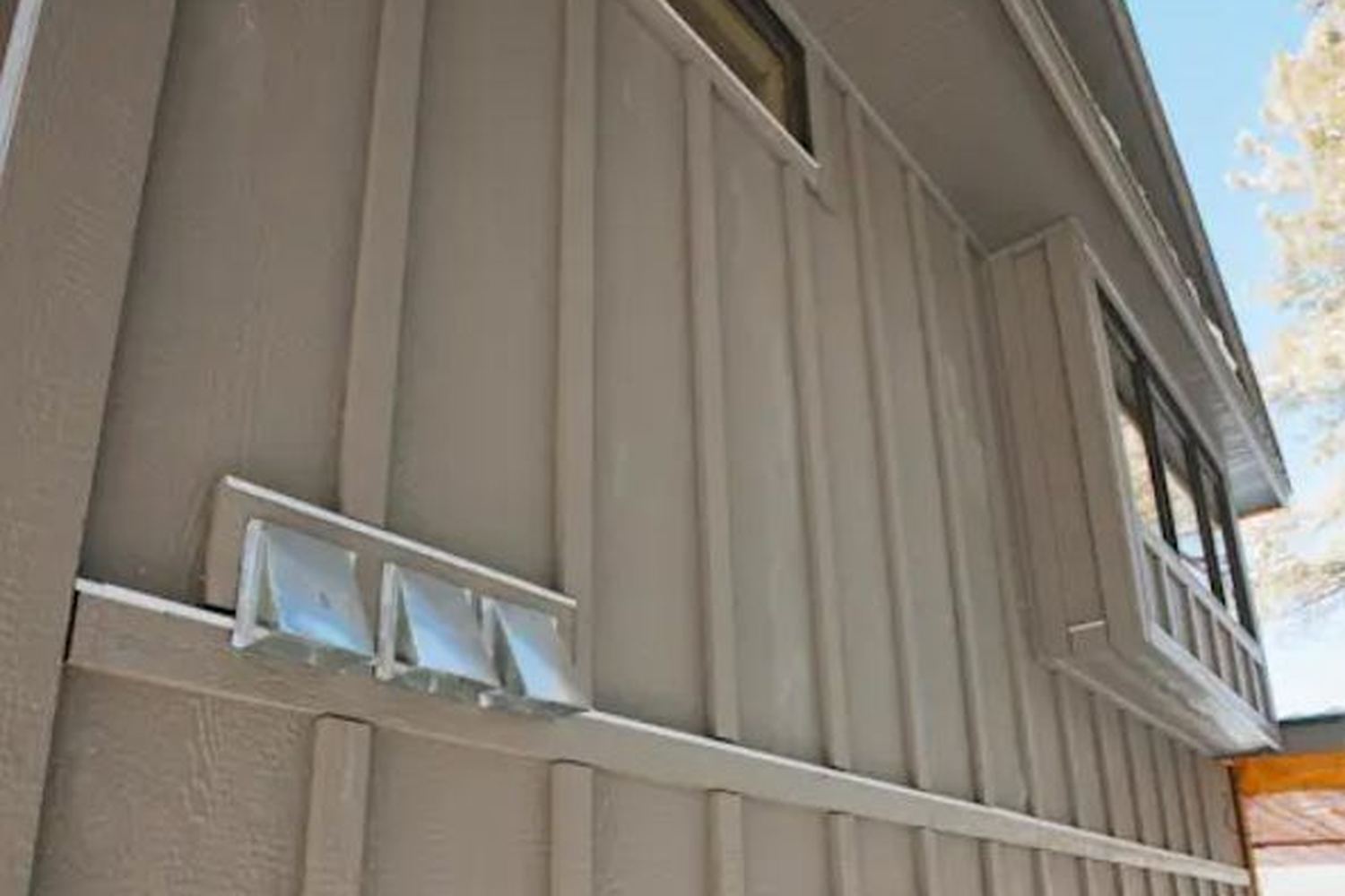 New lap siding being installed over a house wrap weather barrier