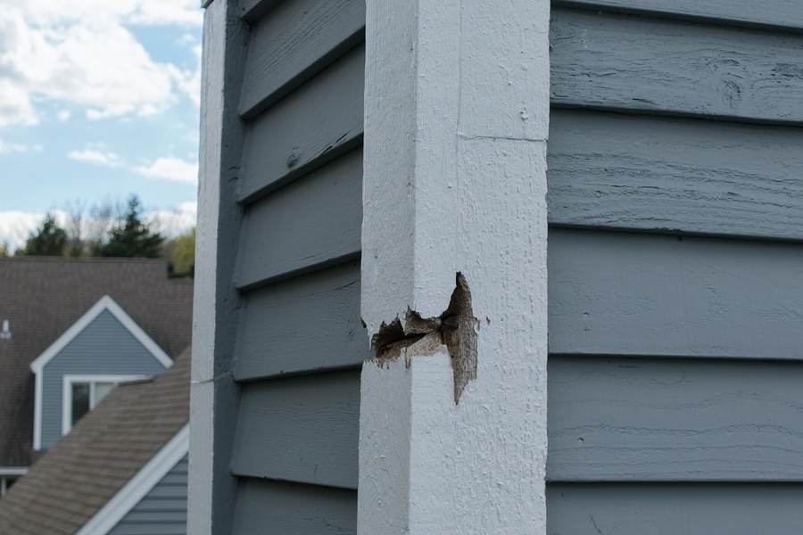 Damaged exterior trim showing rot and separation at a siding transition