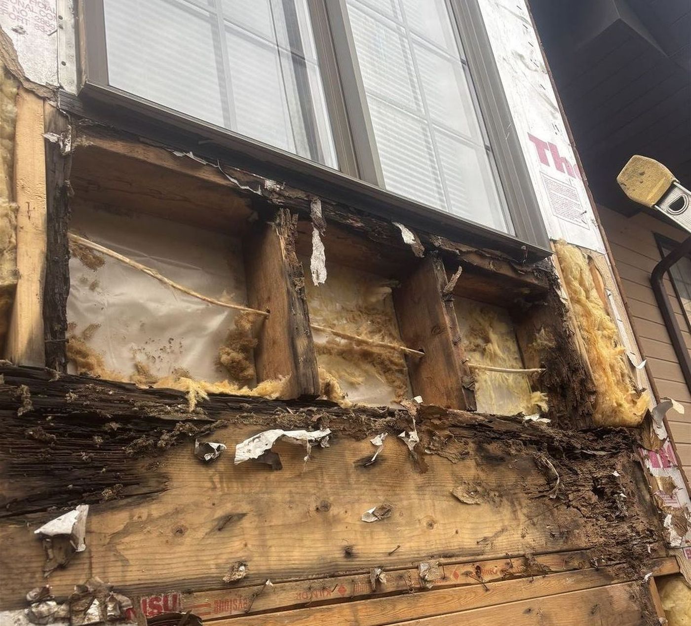 Rotted framing and sheathing below a window opening, siding removed